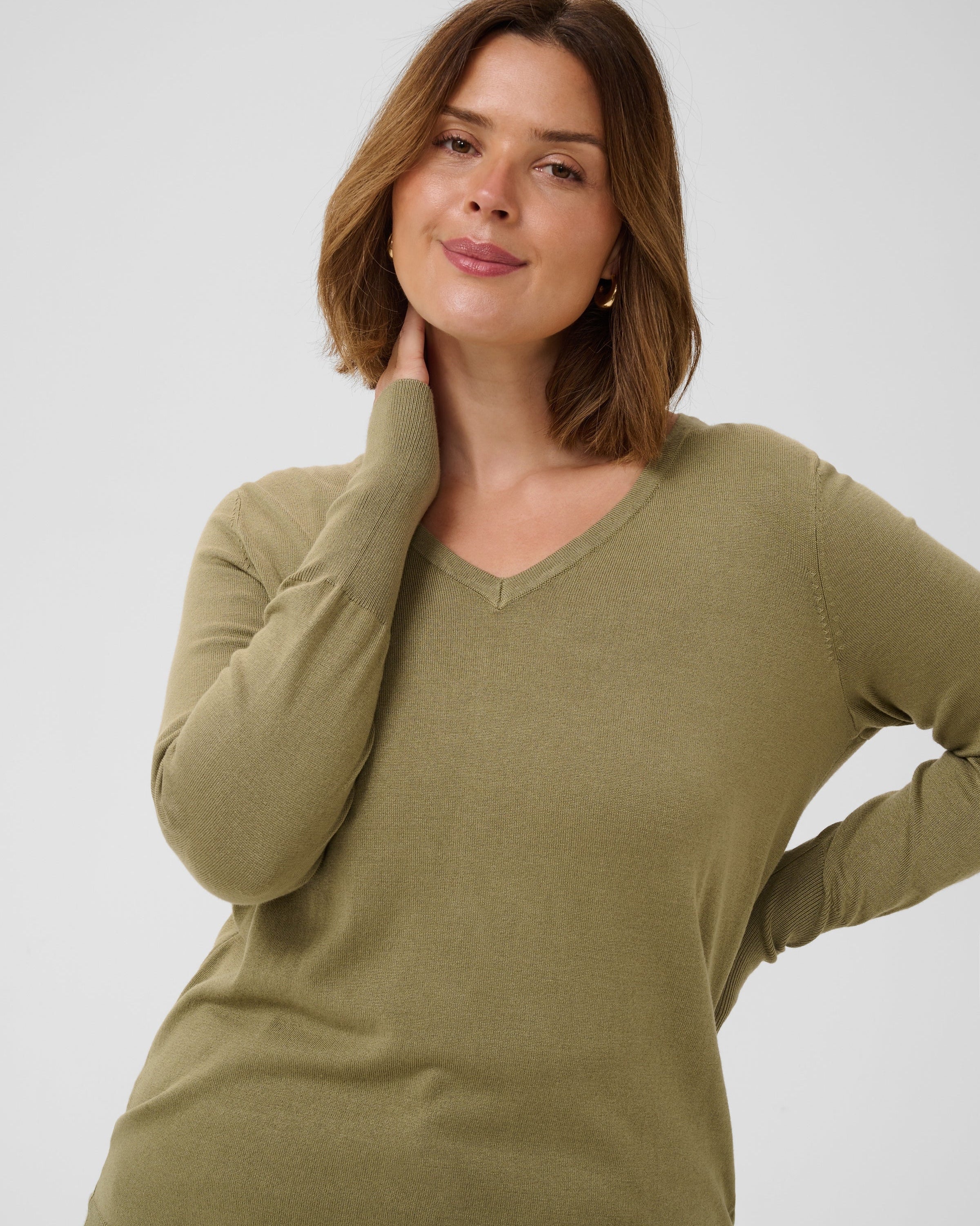 Frau mit hellbraunem Haar und einer türkisblauen Strickjacke