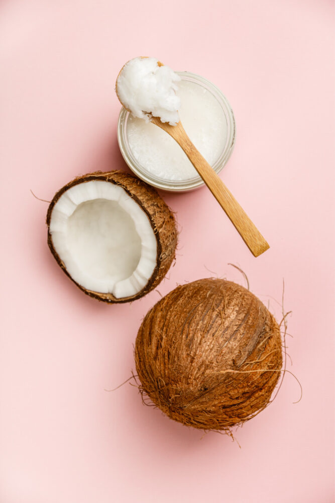 Kokosnuss Kokosöl auf rosa Hintergrund